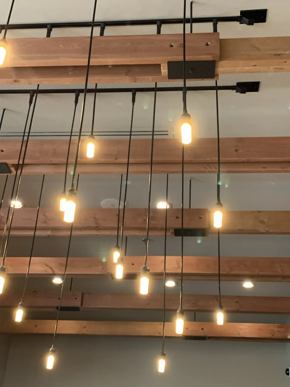 Custom pendant lighting installation over exposed wood beams, Saint Cloud FL